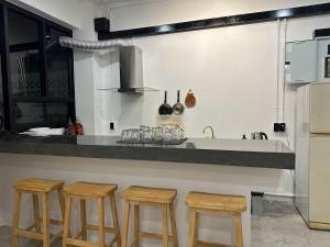 a kitchen with a counter with four stools in it at 9 mins to BTS Queen Bed Private Room - Share Bath in Amphoe Phra Khanong +16 photos