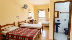 a hotel room with two beds and a bathroom at Hotel 3 meninos in Itariri