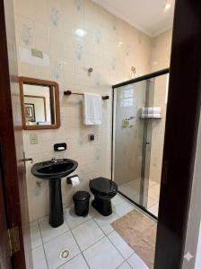 a bathroom with a shower and a toilet and a sink at Hotel 3 meninos in Itariri