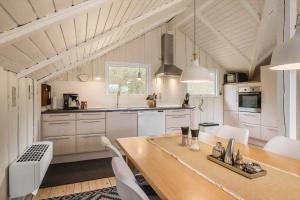 a kitchen with a wooden table and white cabinets at 0658-Toftlund-Ostmarken-56 in Toftlund