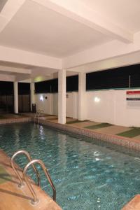 a large swimming pool in a large building at Maison Madame - Female only Shared Apartment Lekki in Lekki