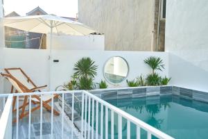 a swimming pool with a chair and an umbrella at Sunny - Việt House in Kỳ Vĩ +14 photos