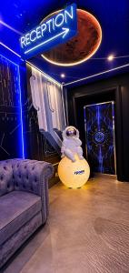 a room with a couch and an astronaut on a drum at Space Hotel KL Sentral in Kuala Lumpur