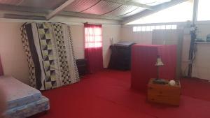 a room with a red floor and a bed and a window at El Campito in Abasto