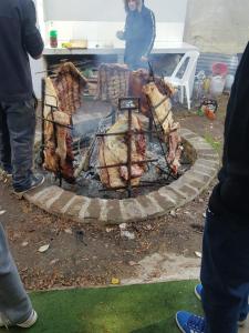a fire pit with meat being cooked on it at El Campito in Abasto +6 photos