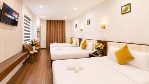 a hotel room with two beds and a tv at Le Centre Pleiku Hotel in Pleiku +64 photos