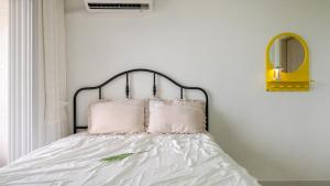a bedroom with a bed with white sheets and pink pillows at Samcheok Sea Road Pension in Samcheok