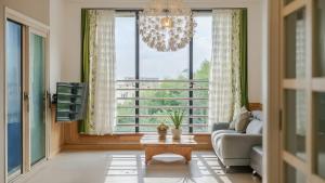 a living room with a couch and a chandelier at Samcheok Sea Road Pension in Samcheok