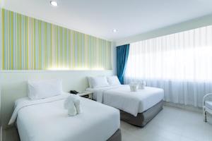 a hotel room with two beds with white sheets at Krabi Royal Hotel in Krabi