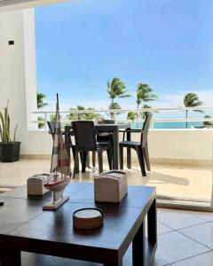 a living room with a table and a balcony at Exclusivo Departamento playa in Same