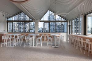 a room with tables and chairs in a building with windows at Bounce Surfers in Gold Coast
