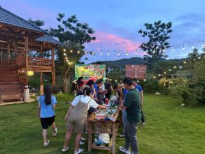 a group of people standing around a table with food at Mountain Hill in Mai Sơn