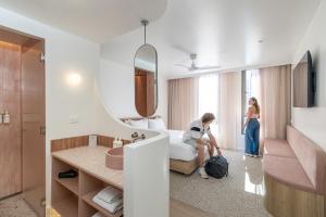 a man sitting on a bed in a hotel room at Bounce Surfers in Gold Coast