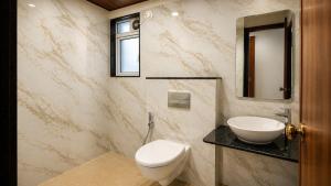 a bathroom with a toilet and a sink and a mirror at ASPA Apartments in Navi Mumbai +34 photos