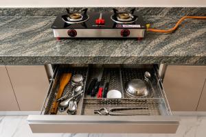 a kitchen counter with a stove on top at ASPA Apartments in Navi Mumbai