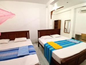 two beds in a room withthritisthritislictslictslicts at Sasagara Beach Villa in Tangalle