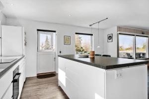 a kitchen with white cabinets and a black counter top at 8242-Vordingborg-Kvaedevej-8 in Bakkebølle Fredskov