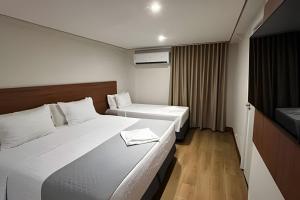 a hotel room with two beds and a television at Hotel Amazon Seasons VN in Belém