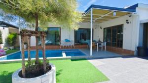 a villa with a swimming pool and a house at บ้านออมPool villa บางแสน sin in Ban Bang Saen (1)
