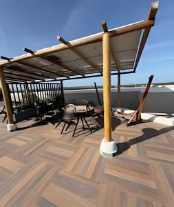 a deck with a pergola and tables and chairs at Flat 2/4 - Prestige 204 - Praia do Francês in Marechal Deodoro