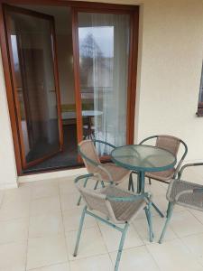 a table and chairs and a glass table and chairs at Villa Amber in Międzywodzie