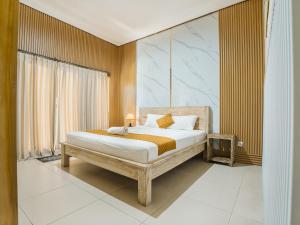 a bedroom with a bed with a wooden frame at Pondok Lulik Homestay Canggu in Canggu