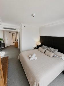 a bedroom with a large bed with two stuffed animals on it at Stunning Oceanview - Beachfront hotel suite in Gold Coast +5 photos