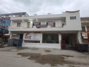 a white building with a sign in front of it at Luxury Heaven Hostel For Couples, Students, Faculties, Corporates in Chaheru