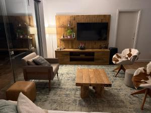 a living room with a tv and a couch and a table at Sítio Paradouro in Novo Hamburgo