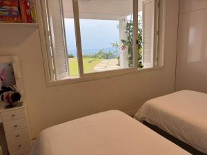 a bedroom with two beds and a window at Sítio Paradouro in Novo Hamburgo