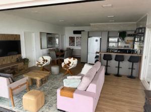 a living room with a pink couch and a kitchen at Sítio Paradouro in Novo Hamburgo