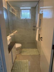 a bathroom with a shower with a toilet and a sink at Sítio Paradouro in Novo Hamburgo +32 photos