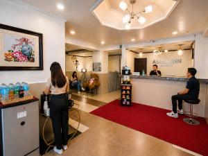 a woman standing at a bar in a hair salon at Amax Inn Makati in Manila