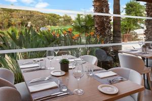 a wooden table with glasses and napkins on a patio at Meliá Lloret de Mar in Lloret de Mar
