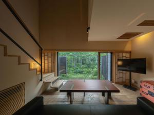 a living room with a table and a large window at OTARU RETREAT KURAMURE by Onko Chishin in Otaru