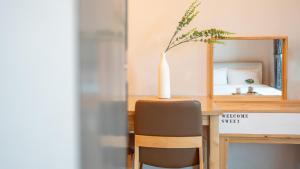 a table with a vase on top of a desk with a chair at Goseong Araenmaru Pension in Goseong +2 photos