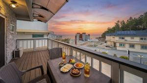 a table with food on a balcony with a view at Goseong Araenmaru Pension in Goseong