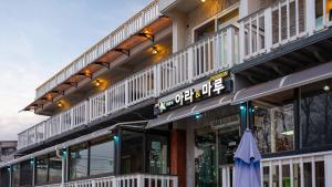 a building with an umbrella in front of it at Goseong Araenmaru Pension in Goseong