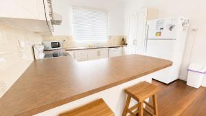 a kitchen with a counter and a white refrigerator at Teke Cottage in Wooli +8 photos