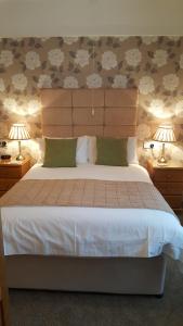 a bedroom with a large bed with two lamps at Tregonwell House - Guest House in Minehead