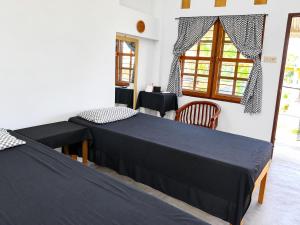 a room with two beds and a table and a window at Kaliele House in Domine Eduard Osok Airport