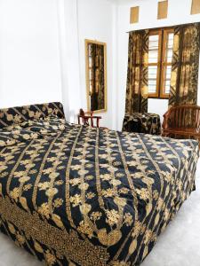 a bedroom with a bed with a blue and white comforter at Kaliele House in Domine Eduard Osok Airport