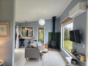 a living room with a couch and a fireplace at Flotsam Seaside Studio Dunalley in Dunalley