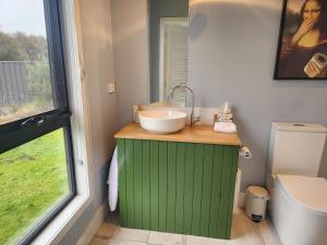 a bathroom with a green cabinet and a sink at Flotsam Seaside Studio Dunalley in Dunalley +78 photos