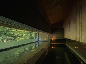 a swimming pool in a building with a large window at OTARU RETREAT KURAMURE by Onko Chishin in Otaru