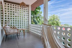 a hammock on the balcony of a house at Crocus Garden in Haad Yao