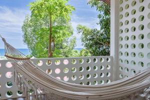 a hammock on a wall with trees and the ocean at Crocus Garden in Haad Yao