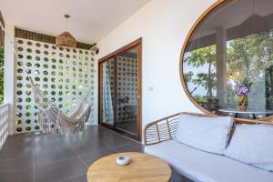 a living room with a couch and a round mirror at Crocus Garden in Haad Yao +19 photos