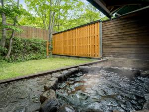 a backyard with a pond next to a building at Wan Wan Paradise Takayama in Takayama