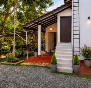 a house with a front porch with stairs and plants at SunBeachHouse in Weligama